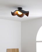 Wood-grain leaf ceiling light glowing softly in a calm interior