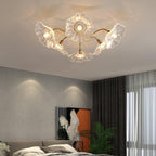 Gold ceiling light with radial frosted glass leaves glowing warmly