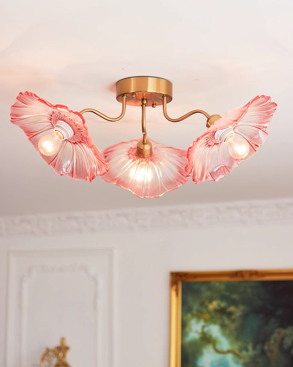Gold ceiling light with frosted leaf glass shades over a table