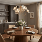Leaf glass chandelier with gold frame against a wall