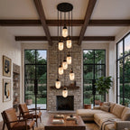 Above a leather sofa and stone fireplace, this Clérachic pendant's alabaster capsules cluster densely under timber beams.