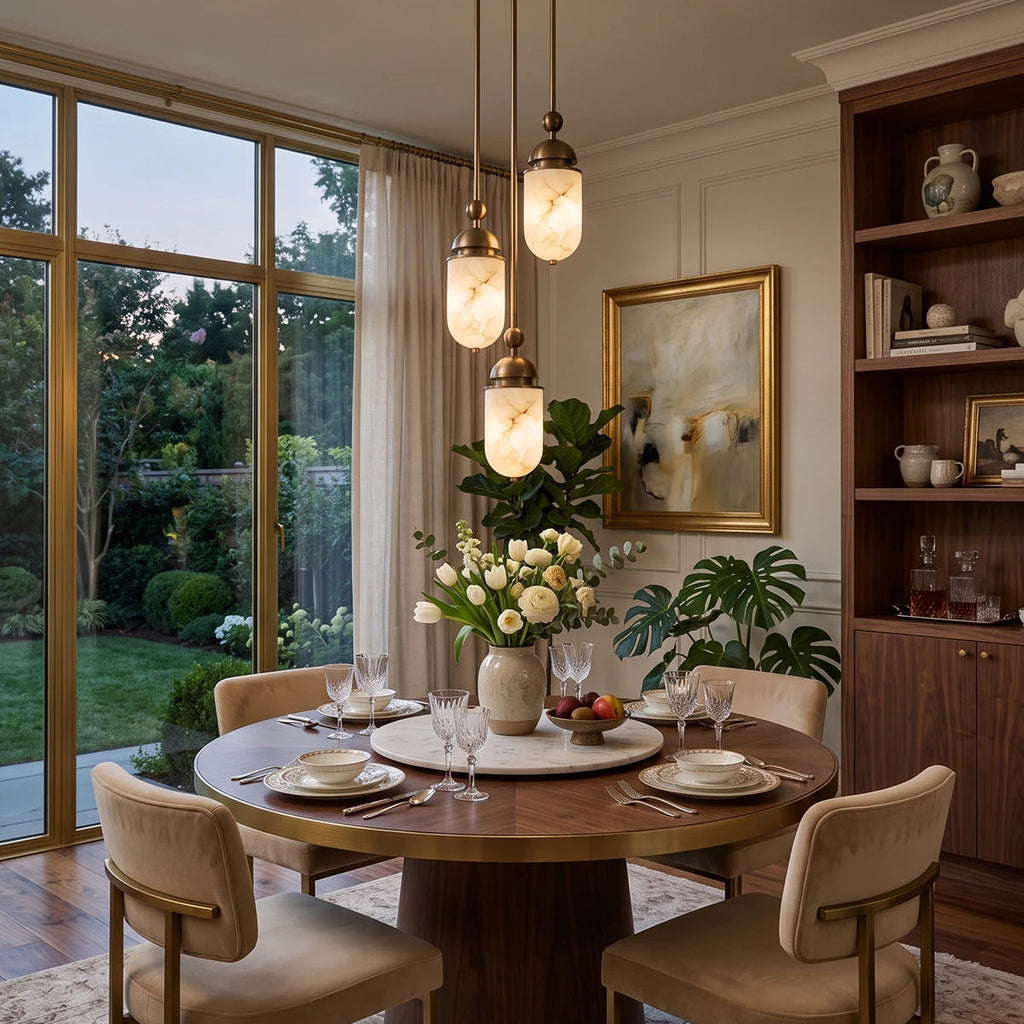 From another angle, this Clérachic pendant's small capsule cluster glows above a round table set for dinner by glass doors.