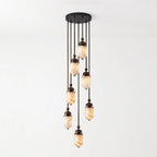 This Clérachic pendant's alabaster capsules stagger down from a round canopy, shown glowing against a plain backdrop.