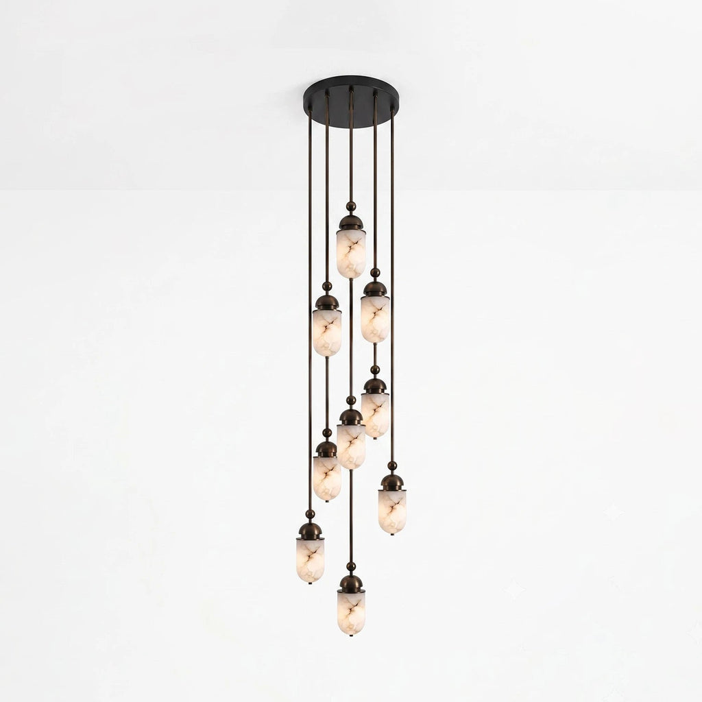 This Clérachic pendant gathers fewer alabaster capsules into a looser staggered cluster, glowing against a plain backdrop.