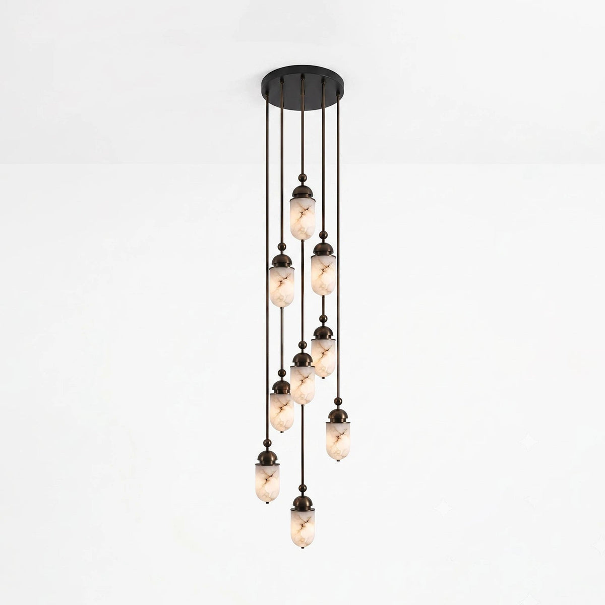 This Clérachic pendant gathers fewer alabaster capsules into a looser staggered cluster, glowing against a plain backdrop.