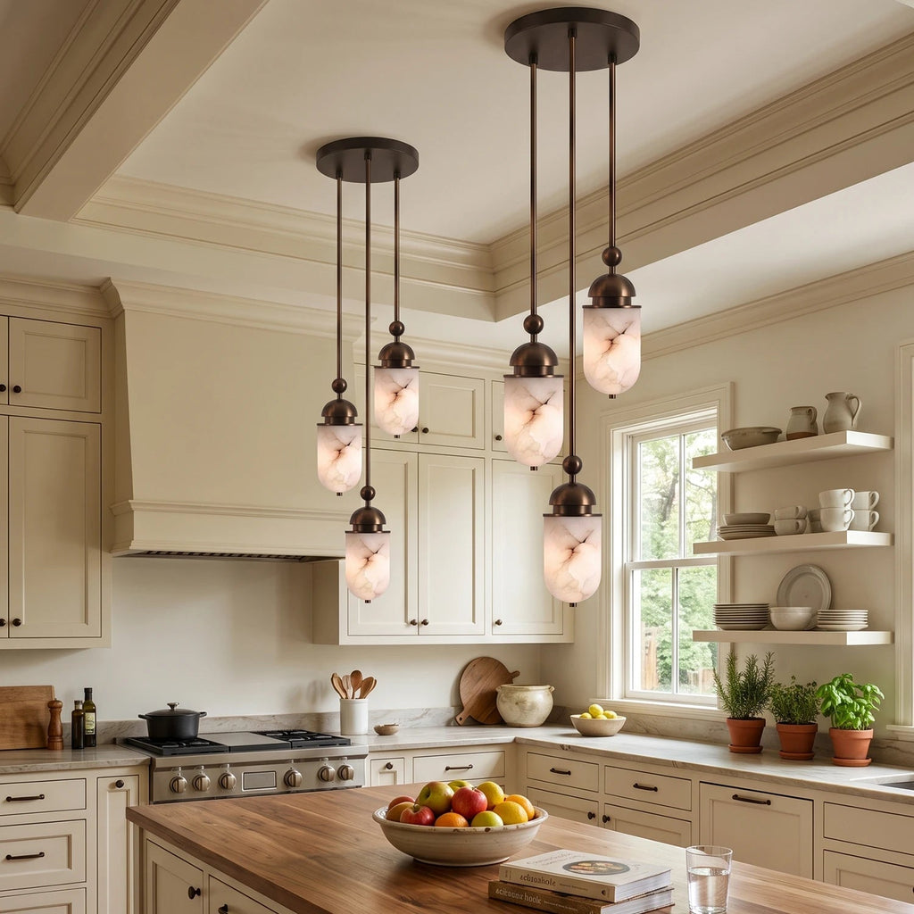 Above a kitchen island with open shelving, this Clérachic pendant's alabaster capsules glow warm in a loose cluster.