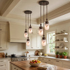 Above a kitchen island with open shelving, this Clérachic pendant's alabaster capsules glow warm in a loose cluster.
