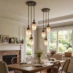 In a bright bay-window dining room with a brick hearth, this Clérachic pendant's alabaster capsules glow warm overhead.