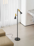 A curved white wall and marble table sit behind a beige sofa and a black and brass Clérachic floor lamp.