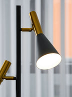 Close-up of both shade heads on a Clérachic floor lamp, brass necks and black cones against a blurred marble surface.