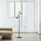 Sheer curtains fill the window beside a beige leather chaise and a black and brass Clérachic floor lamp close by.