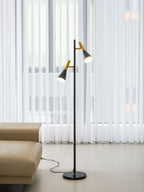A building outline shows through sheer curtains, seen further back in the room with a black and brass Clérachic floor lamp.