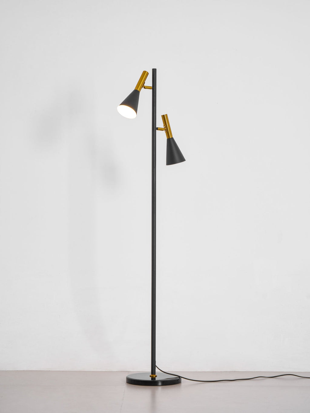 Black Clérachic floor lamp shown alone on a plain white studio background, its own shadow cast beside it.