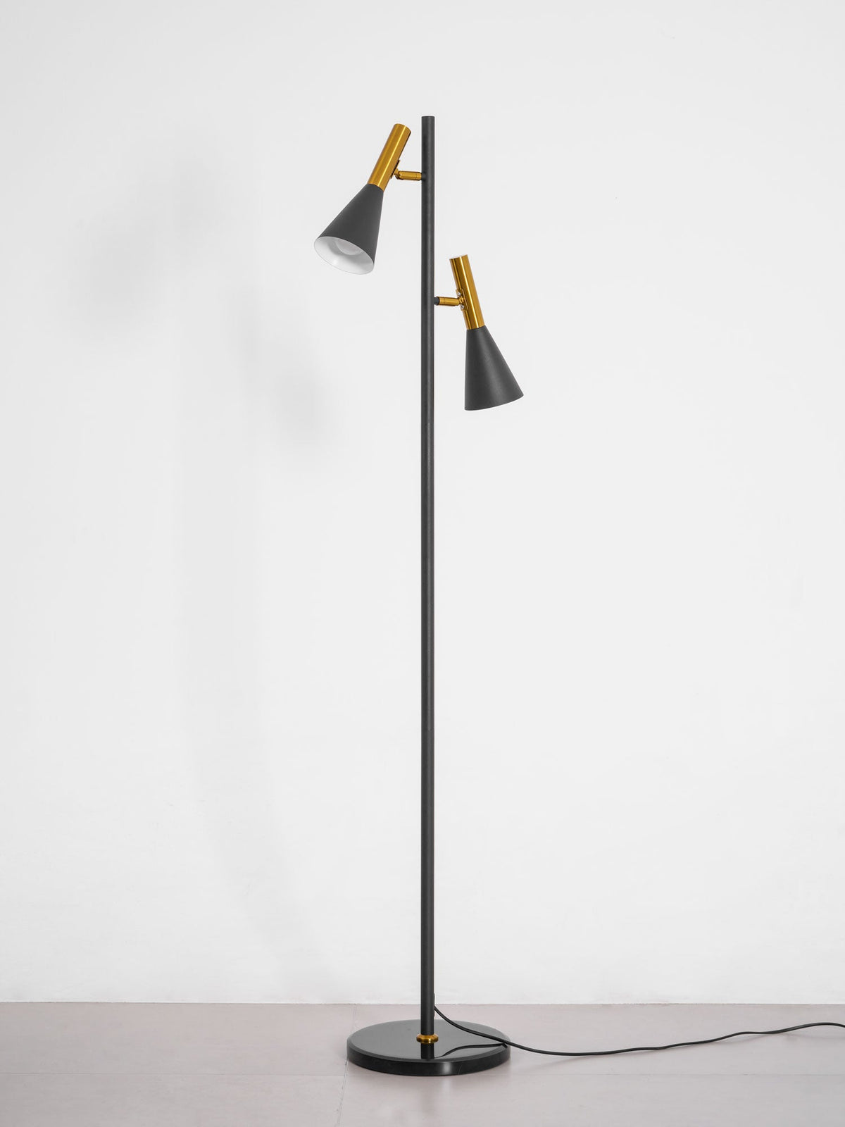 Black Clérachic floor lamp on a round marble base, photographed alone on a plain white studio backdrop.