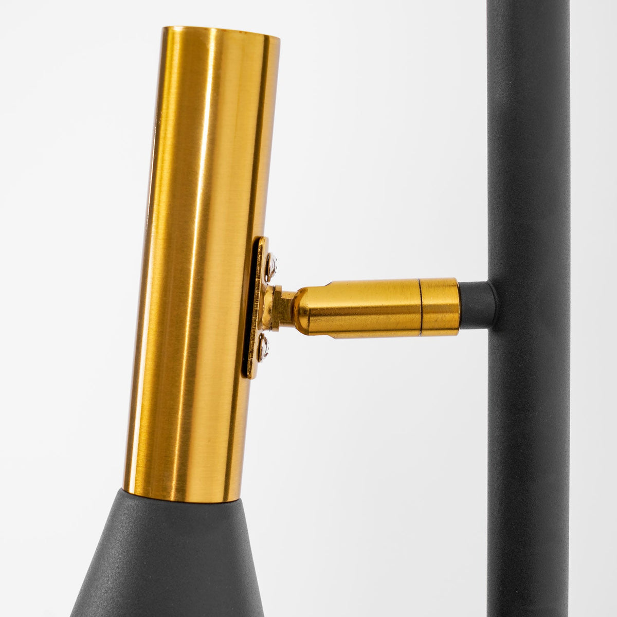 Close-up of the brass swivel joint on a Clérachic floor lamp, showing how the cone shade pivots on the black pole.