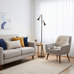 A grey sofa with mustard cushions sits opposite an armchair and side table, a black and brass Clérachic floor lamp between them.