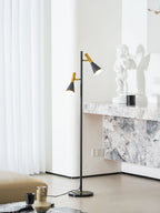 A small statue tops a marble console table beside a black and brass Clérachic floor lamp, a sheer curtain behind.