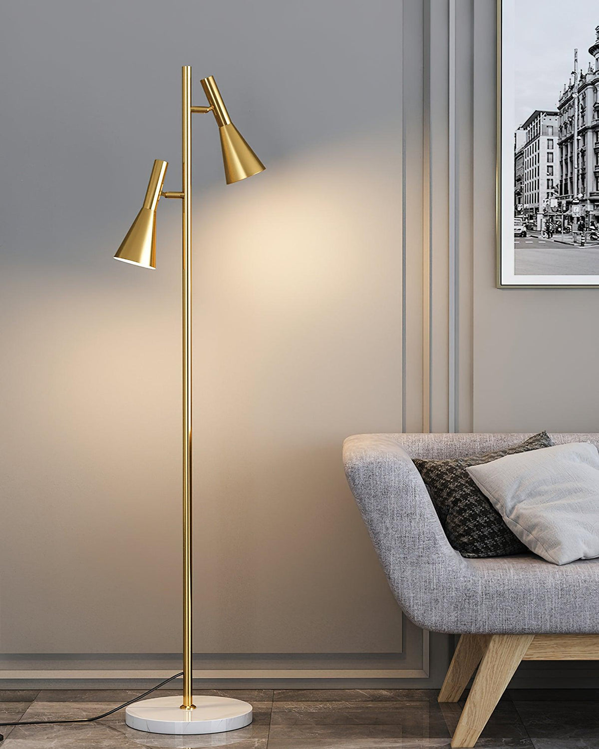 A houndstooth cushion and cityscape print dress a grey sofa beside a brass Clérachic floor lamp on its marble base.