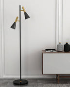 Bowls and vases fill a wood console table against a white wall beside a black and brass Clérachic floor lamp.