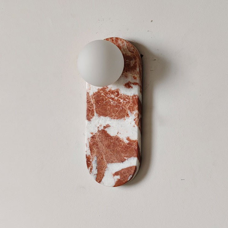 Product view of the Clérachic sconce in deep red marble with fine veining, glass shade unlit on a plain wall.