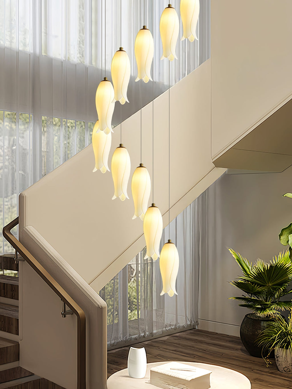 Close view of the ceramic shades lit beside a staircase, sheer curtains and a potted palm behind