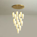 Sixteen-light Sylirion lit against a grey studio wall, gold ceiling plate visible above the cluster