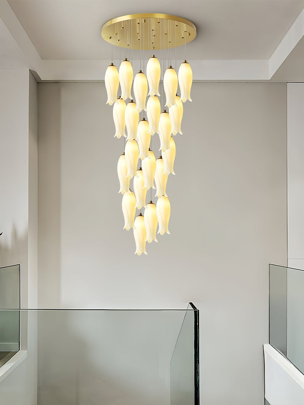 Sylirion lit above a glass balustrade in a plain white stairwell, shades tapering to a single tip