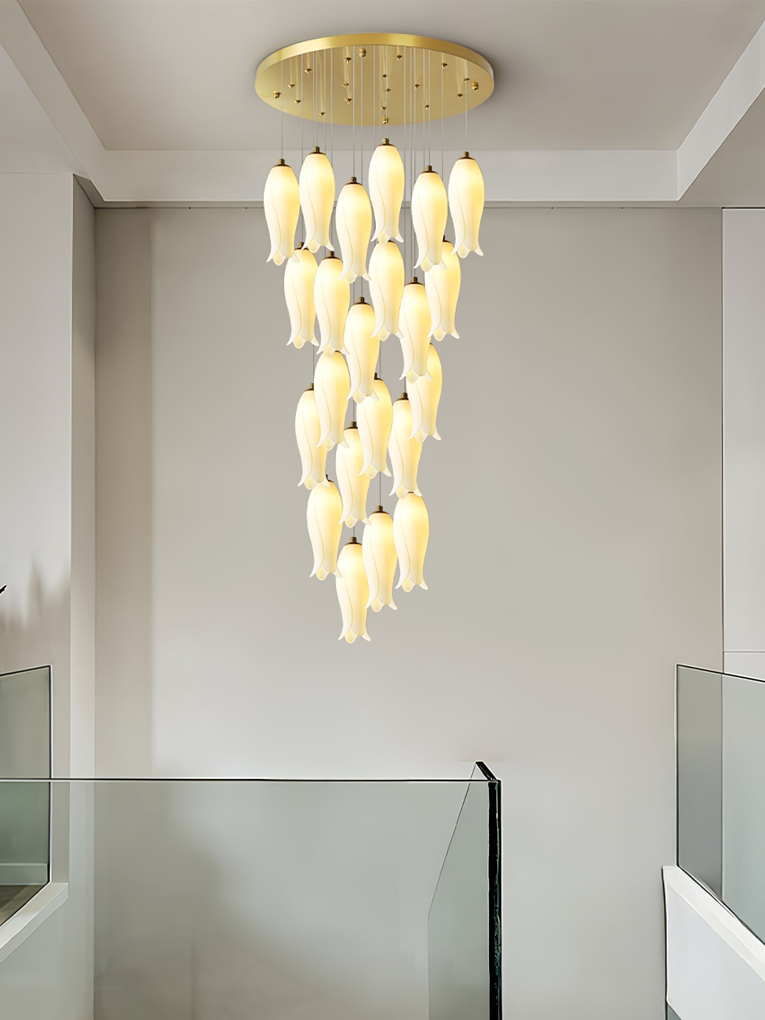 Sylirion lit above a glass balustrade in a plain white stairwell, shades tapering to a single tip