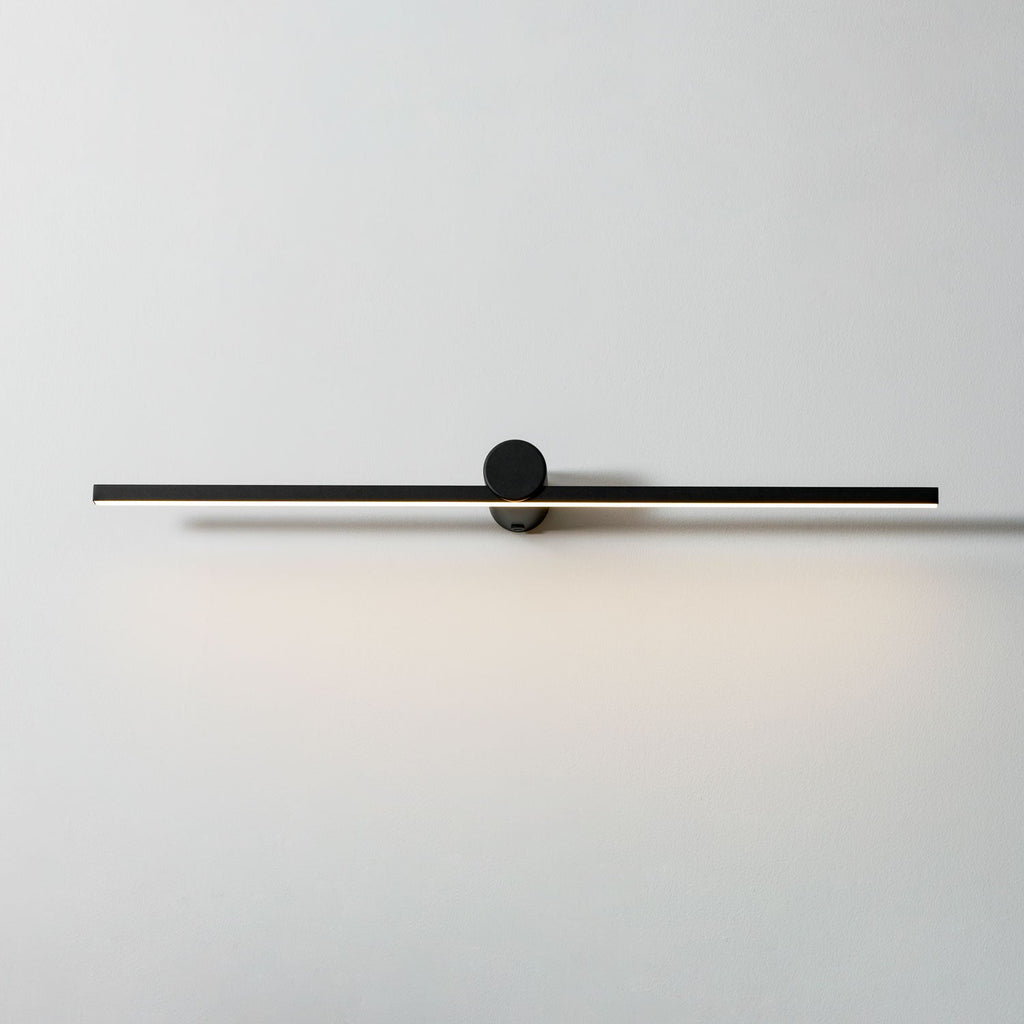 Studio shot of a Clérachic wall light glowing warm, front view against a plain white backdrop.