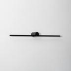 Close studio view of an unlit Clérachic wall light's round pivot mount and slim bar.