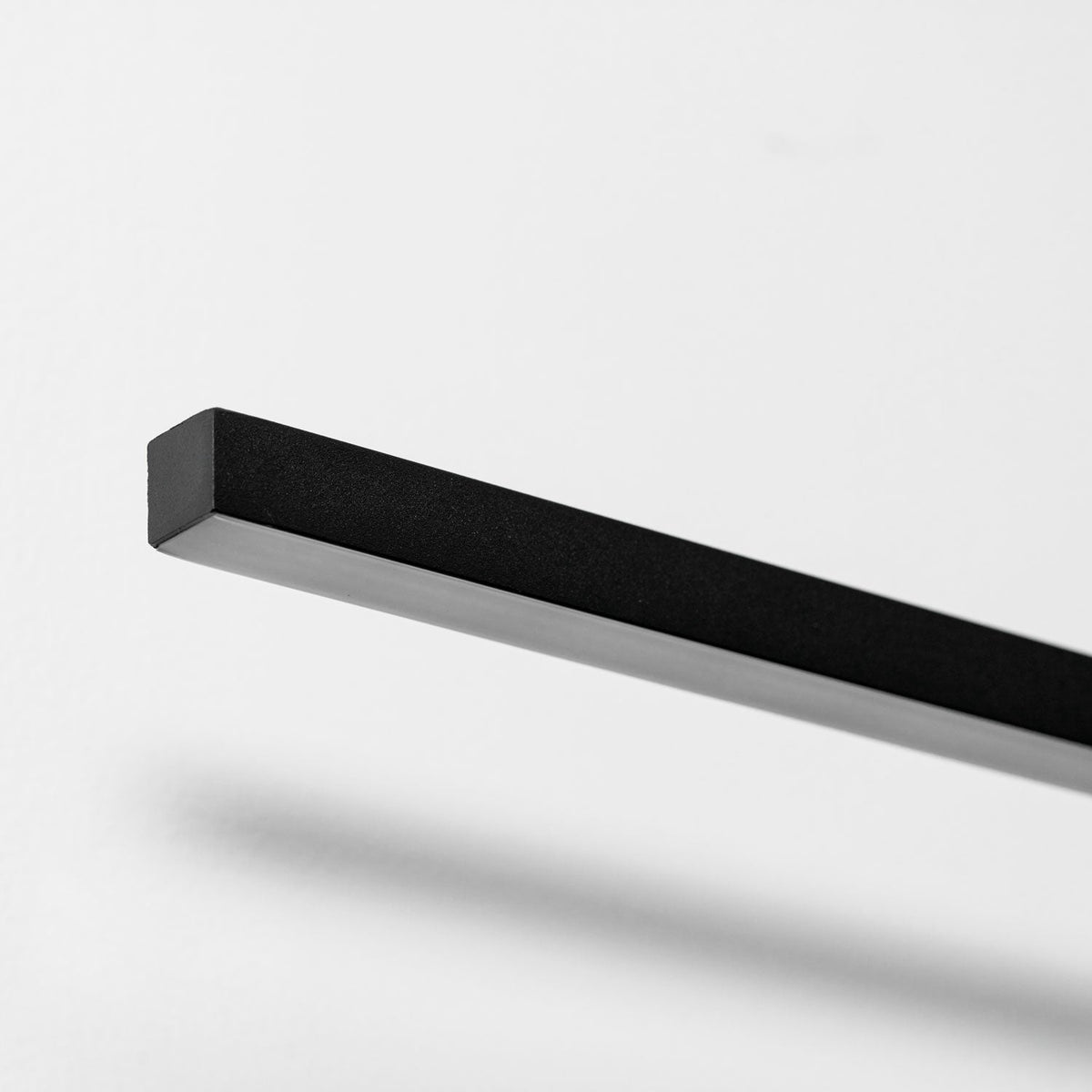 Close view of the matte, square-edged aluminium bar on this Clérachic wall light.