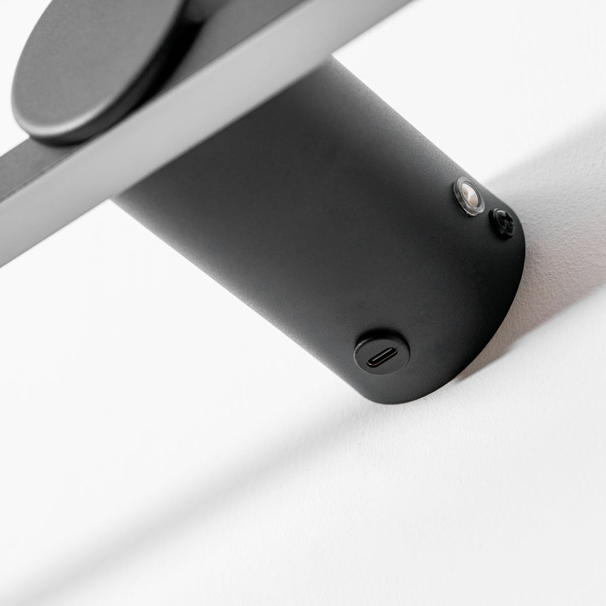 Extreme close view of this Clérachic wall light's mounting cylinder, showing its sensor and fixing screw.