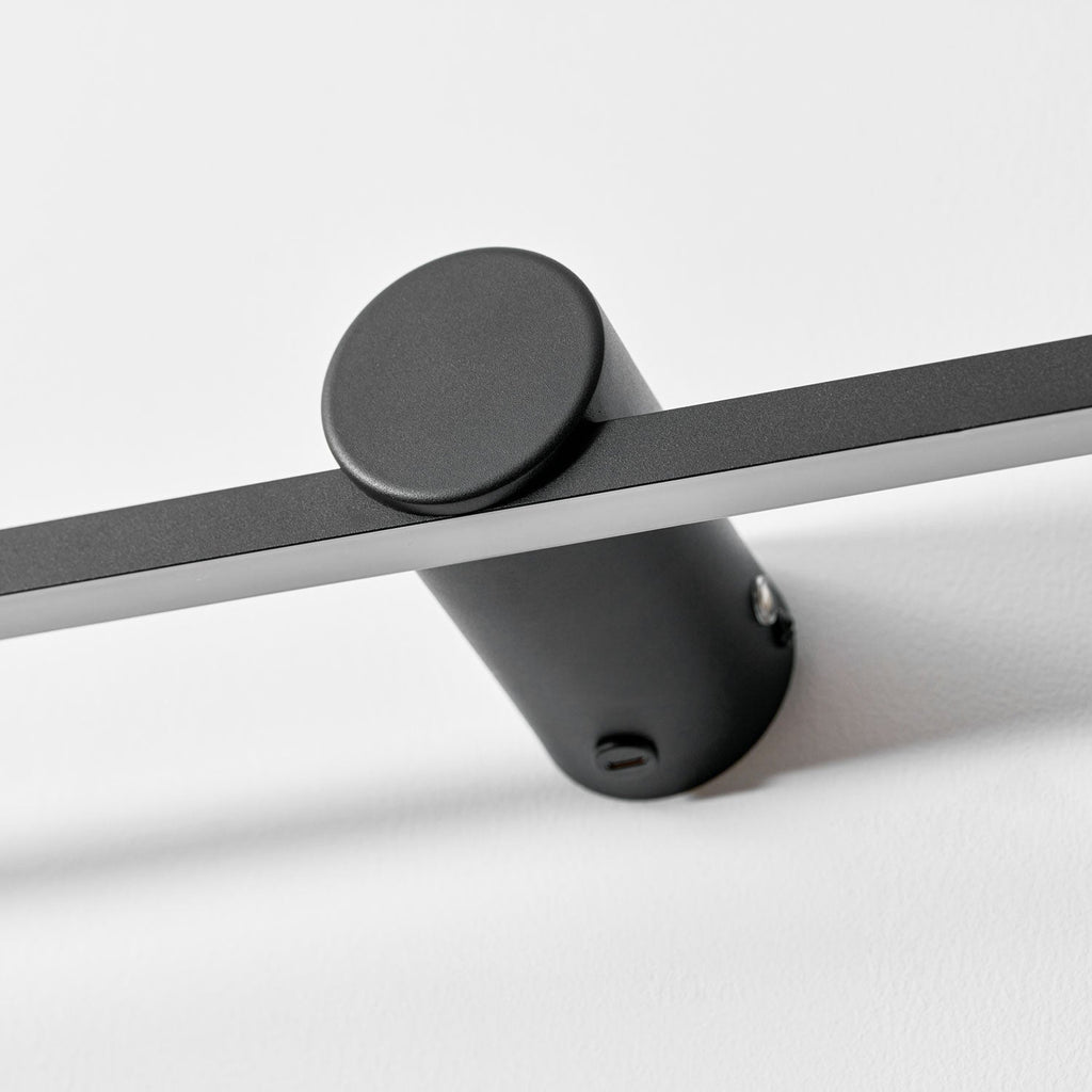 Extreme close view of this Clérachic wall light's round mount, showing its touch control and fixing screw.