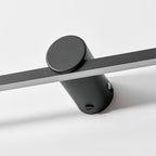 Extreme close view of this Clérachic wall light's round mount, showing its touch control and fixing screw.
