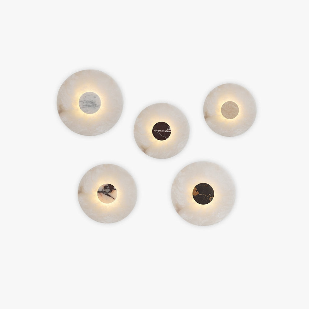Clérachic alabaster wall sconce shown in five finish options, each soft-edged stone disc glowing warm around a different coloured centre panel.