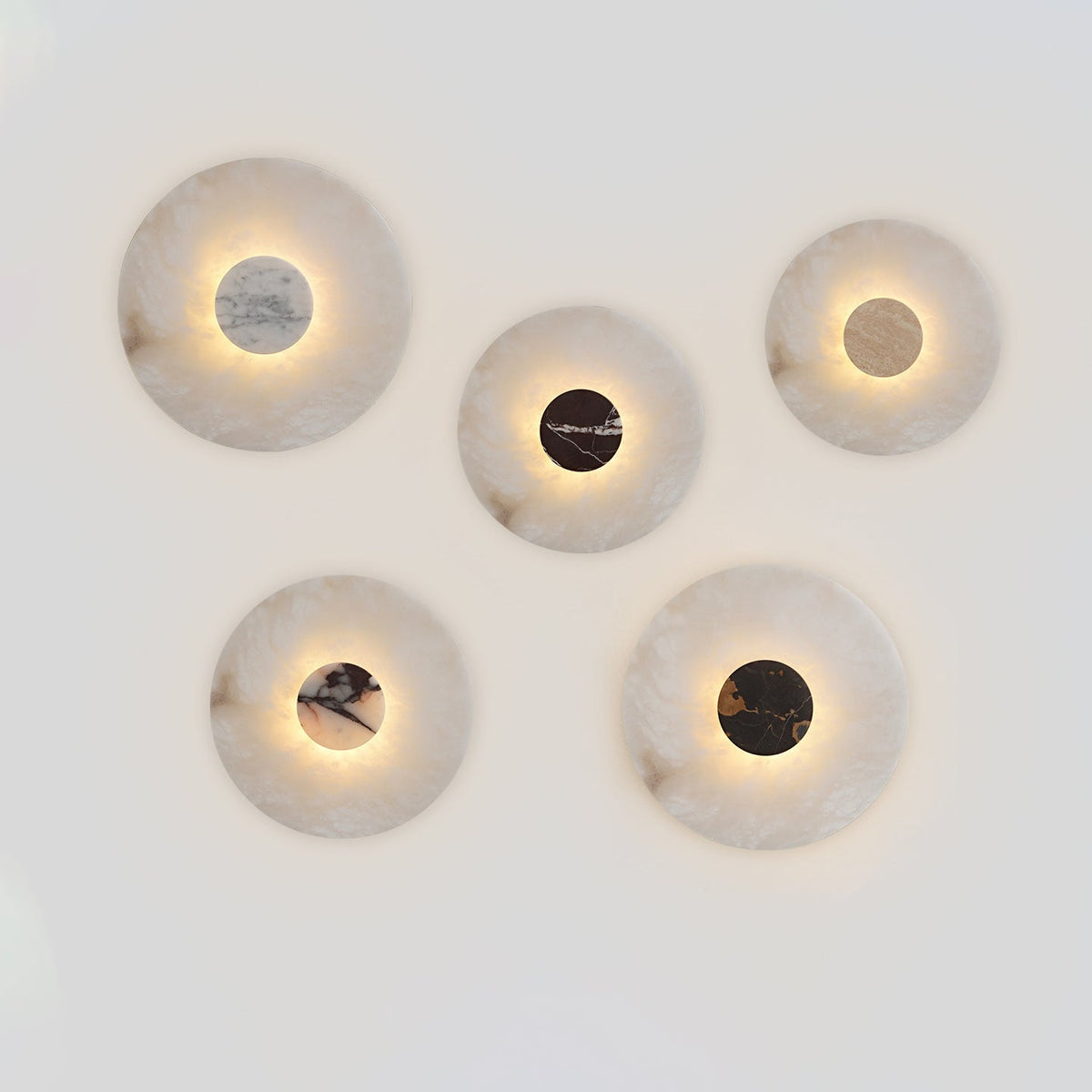Five Clérachic alabaster disc wall lights arranged on a plain background, each centre stone a different marble colour.