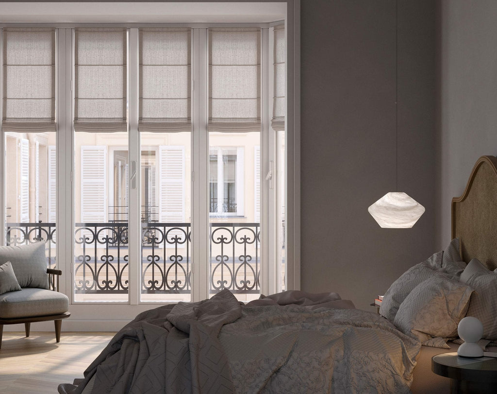 Tyler pendant hanging beside a bed in a daylit bedroom with tall French windows and a wrought-iron balcony.