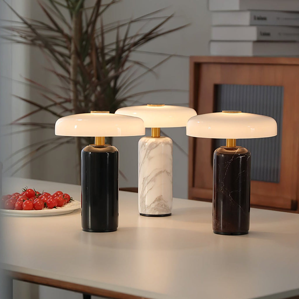 Marble table lamp lit warm on a bedside table