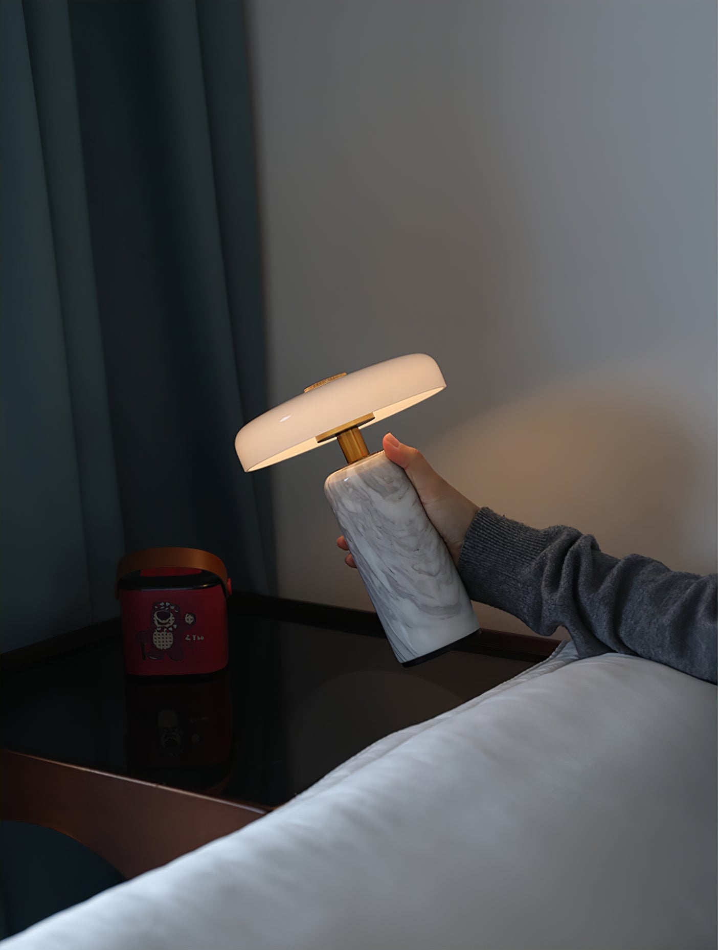 Marble base table lamp glowing on a bedside table