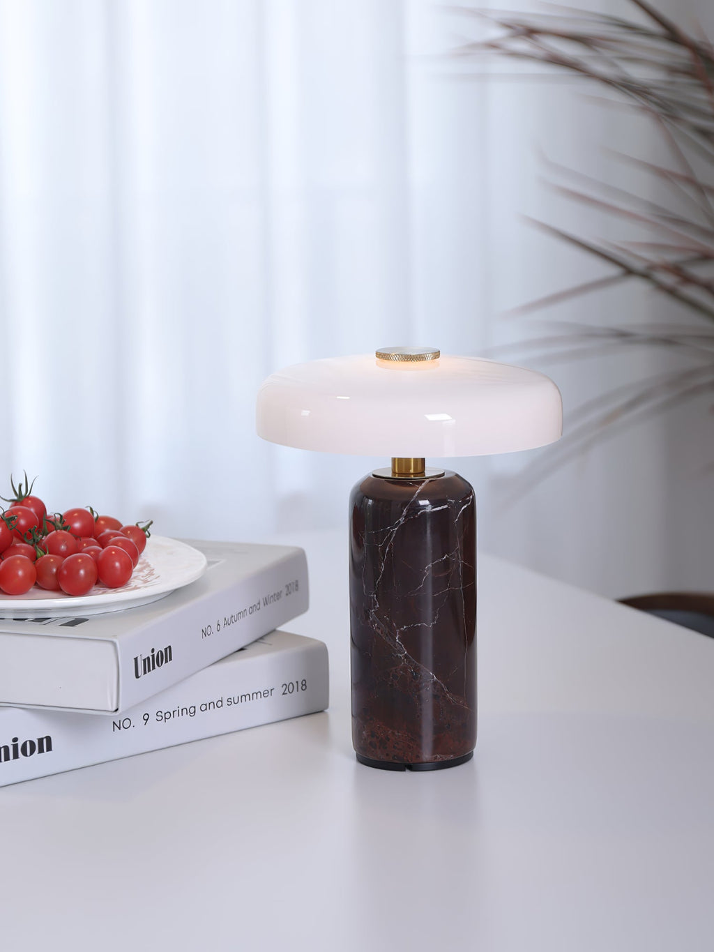 Marble table lamp glowing warm beside a chair
