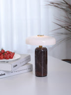 Marble table lamp glowing warm beside a chair