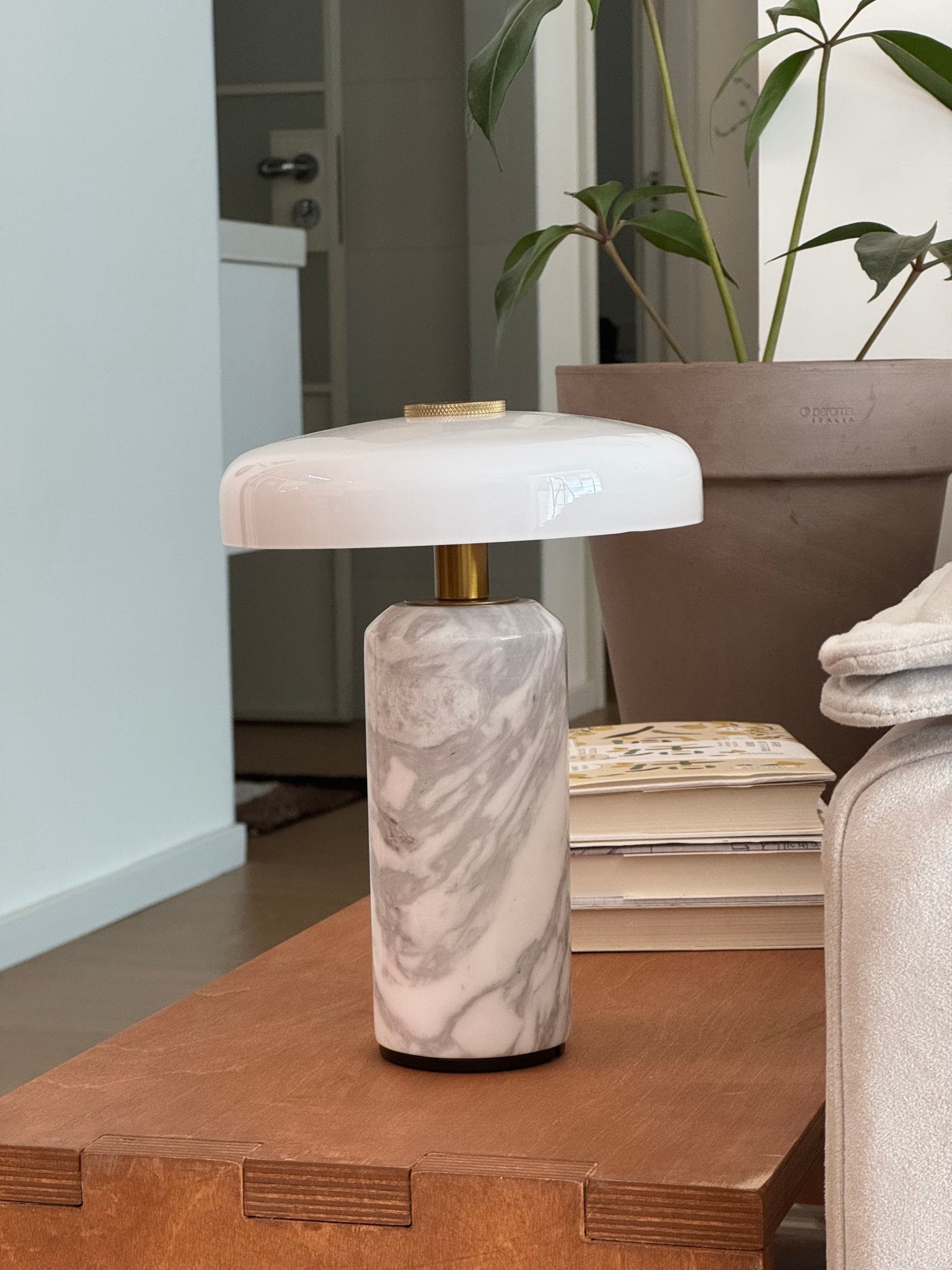 Cordless marble table lamp with a warm glowing shade