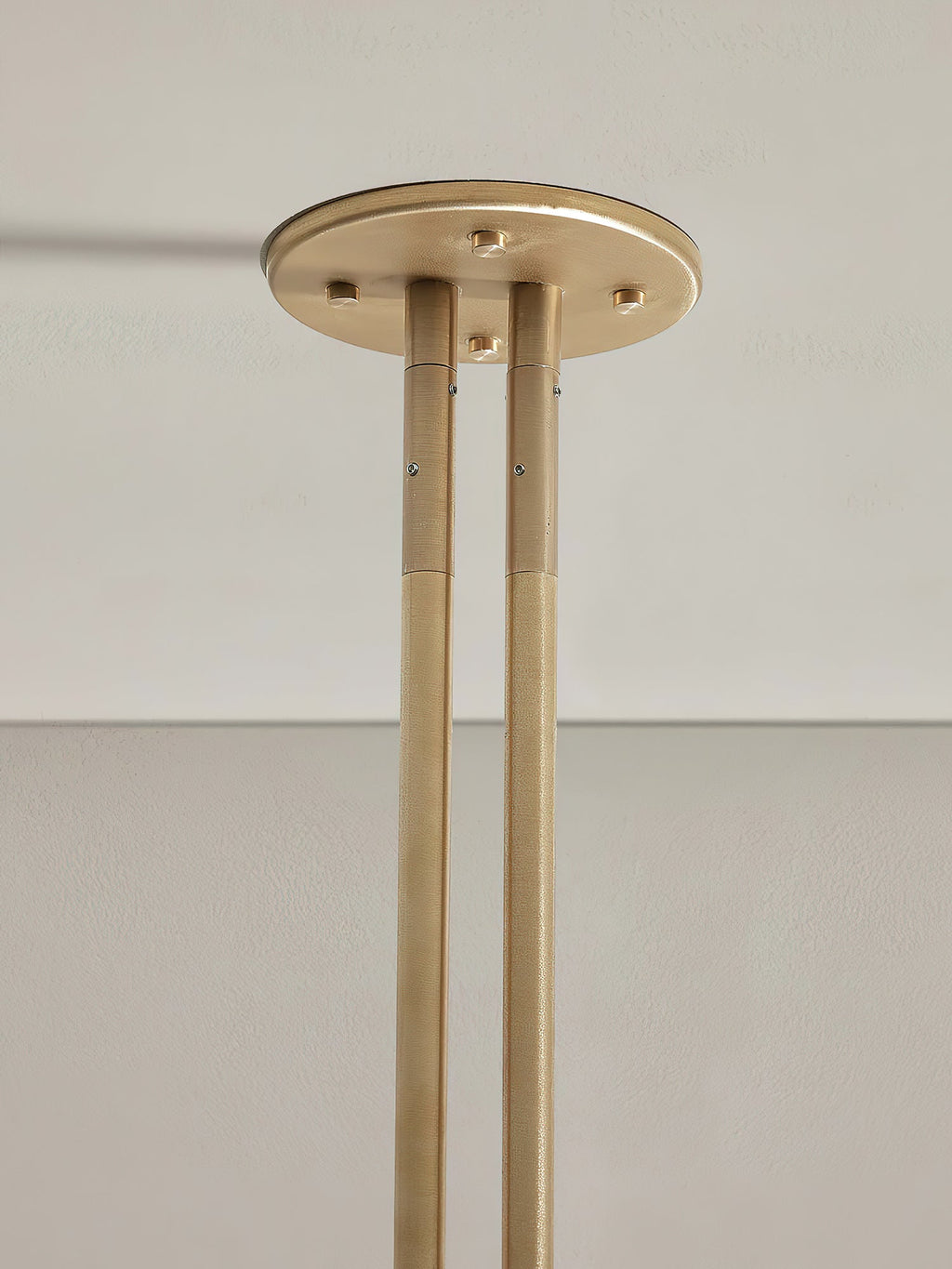 Detail of the Clérachic brass ceiling canopy, showing the two brushed rods bolted into the round mount.