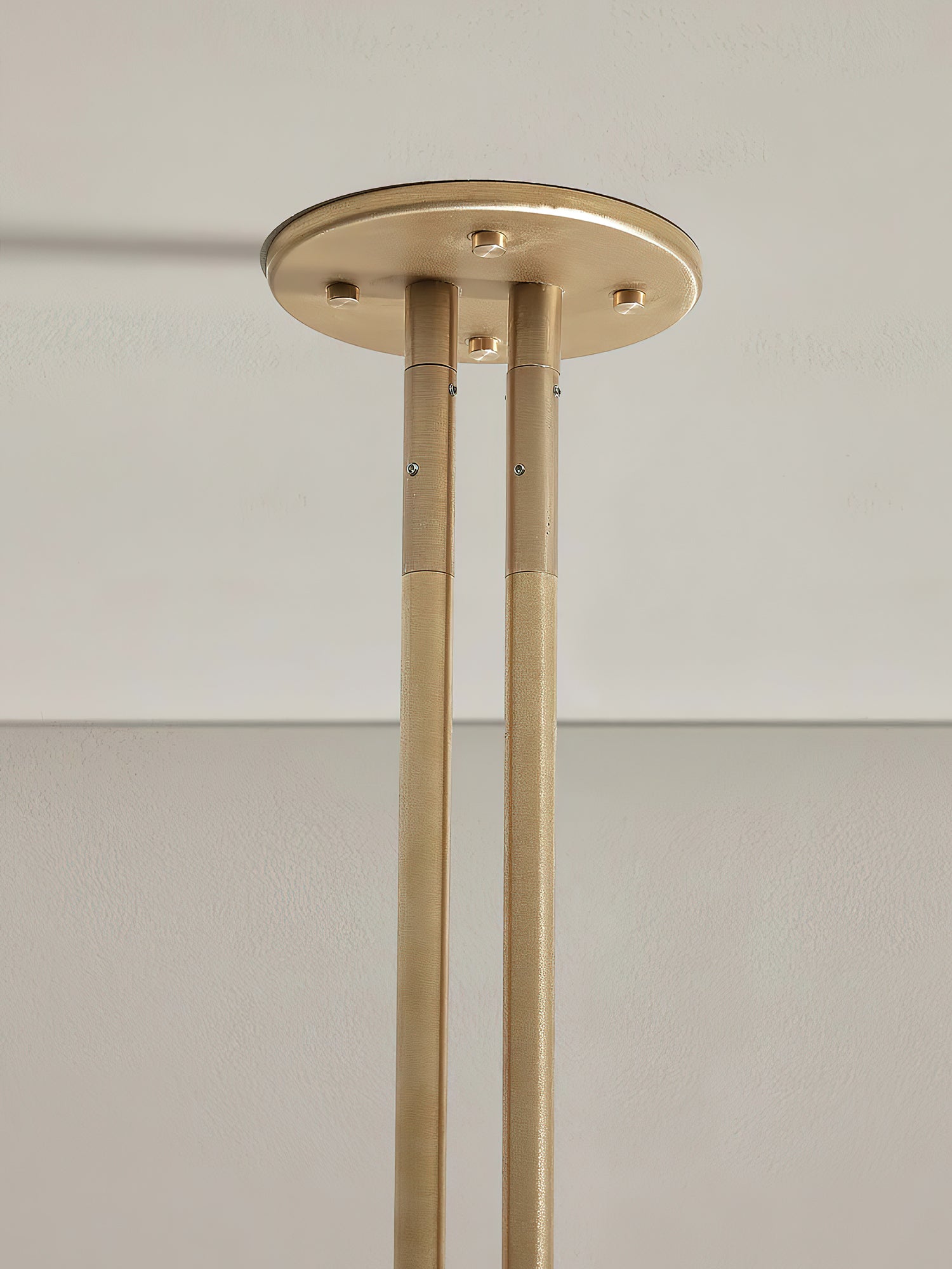 Detail of the Clérachic brass ceiling canopy, showing the two brushed rods bolted into the round mount.