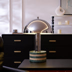 Clérachic lamp lit on the dresser with the candle shelf behind, a wider view taking in more of the dark room.