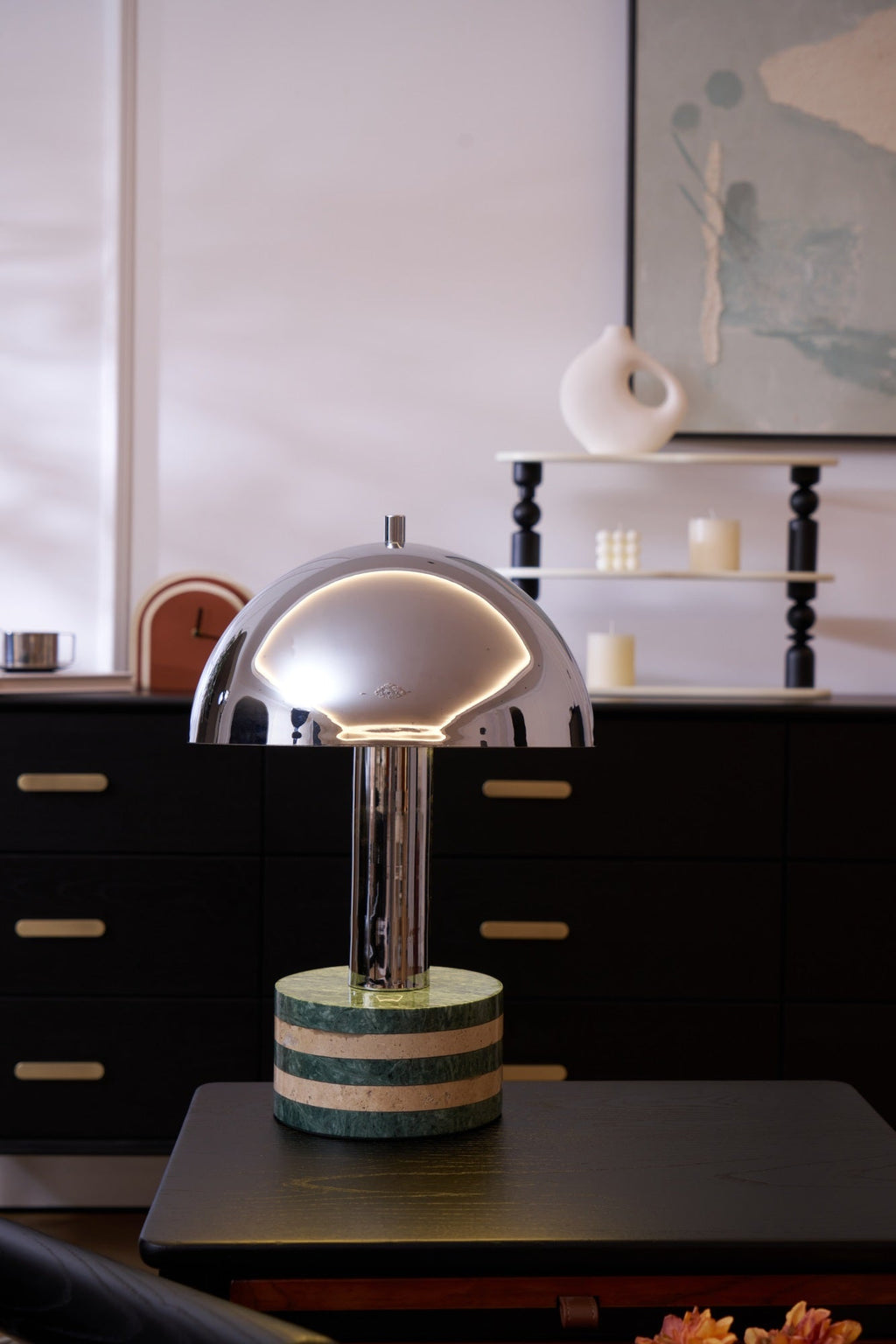 Portrait crop of the Clérachic lamp on the dresser, the tall turned-wood shelf and candles rising behind it.