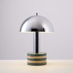 Clérachic table lamp photographed unlit against a plain off-white backdrop, its full chrome dome and marble base visible.