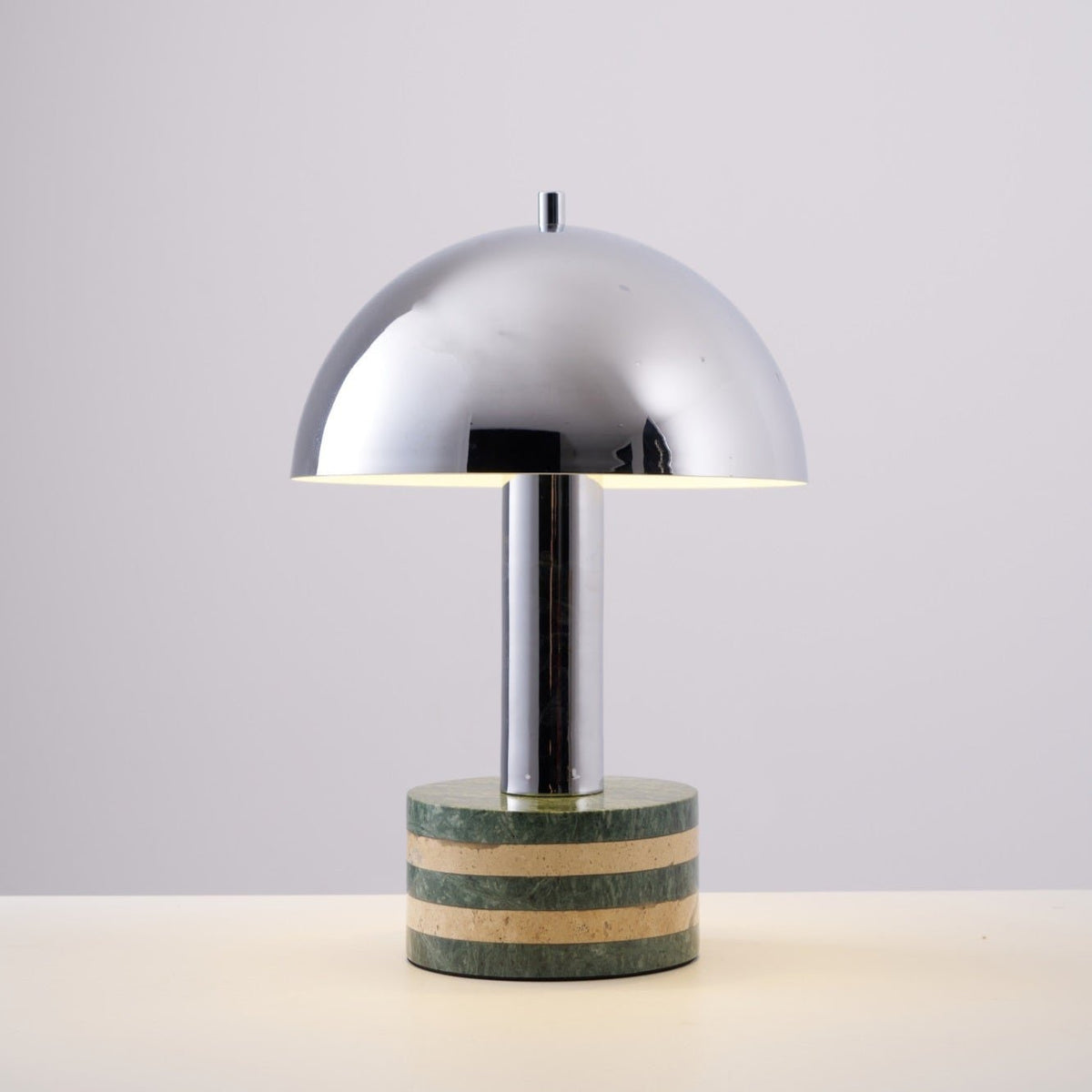 Clérachic table lamp photographed unlit against a plain off-white backdrop, its full chrome dome and marble base visible.
