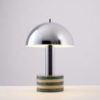 Studio shot of the Clérachic lamp against a plain grey backdrop, dome and striped marble base shown straight-on.