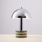 Clérachic lamp on a grey backdrop at a slight angle, a soft shadow falling from its marble base onto the surface.